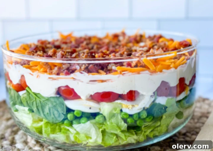 Classic Seven-Layer Salad 3 A serving of 7 layer salad in a bowl, showing the distinct layers and creamy dressing.