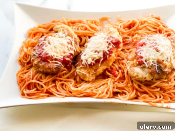 Effortless Chicken Parmesan 7 Close-up of a chicken parmesan dish with spaghetti, ready to serve