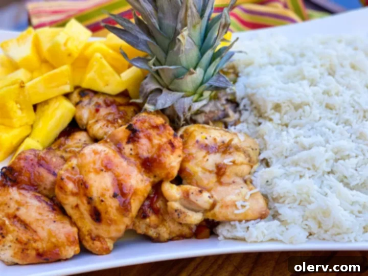 Ultimate Grilled Teriyaki Chicken 6 Grilled teriyaki chicken served on a plate with coconut rice and fresh pineapple slices.