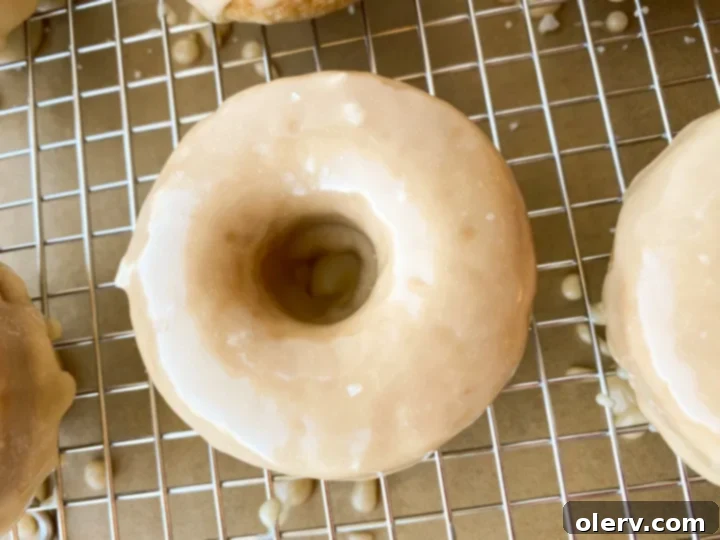 Effortless Maple Baked Donuts 6 A saucepan with maple glaze being whisked, showing its smooth, glossy texture.