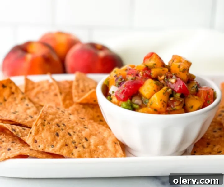 Sun-Kissed Peach Salsa 3 A bowl of fresh peach salsa served with a plate of crispy tortilla chips, perfect for dipping.