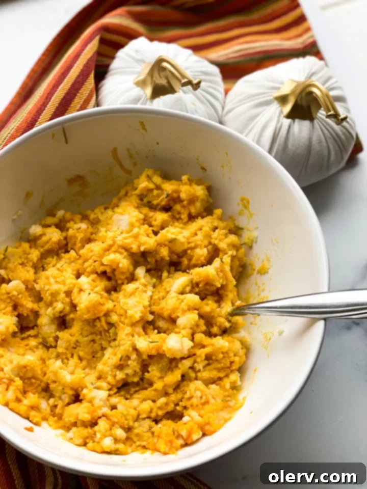 Cheddar Pumpkin Mashed Potatoes garnished with rosemary