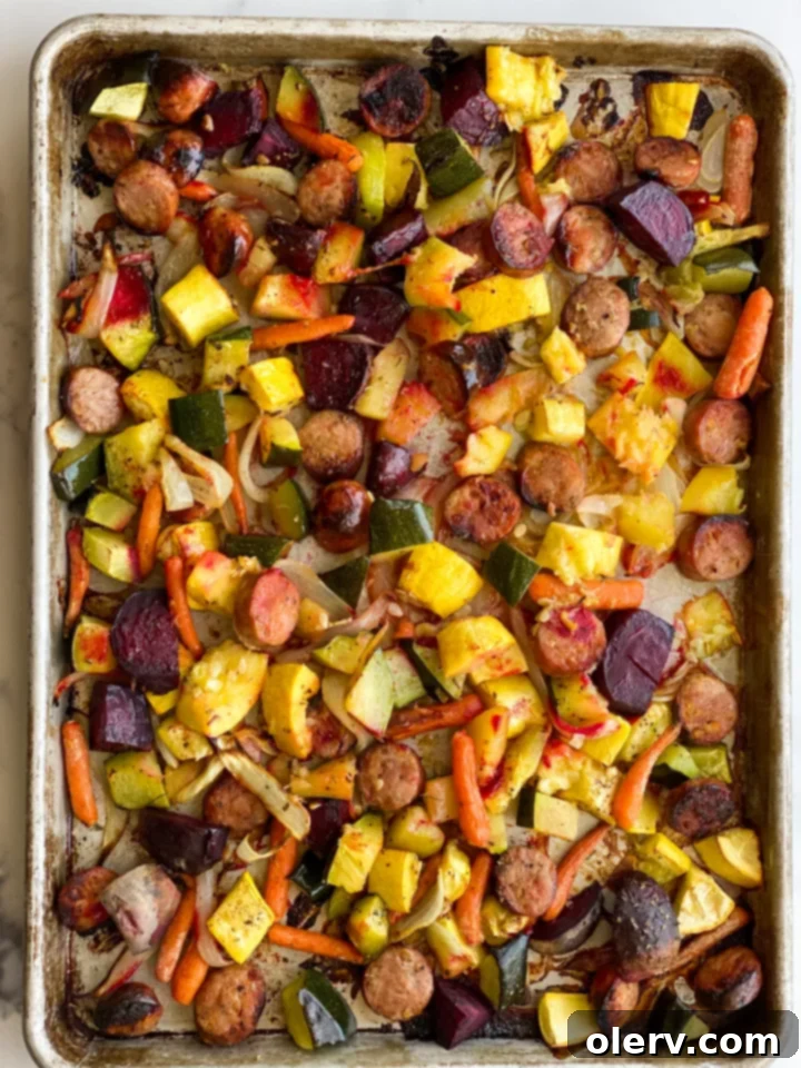 Sheet Pan Sausage and Roasted Veggies 8 A perfectly roasted sheet pan dinner with chicken and apple sausage and various vegetables, ready to be served.