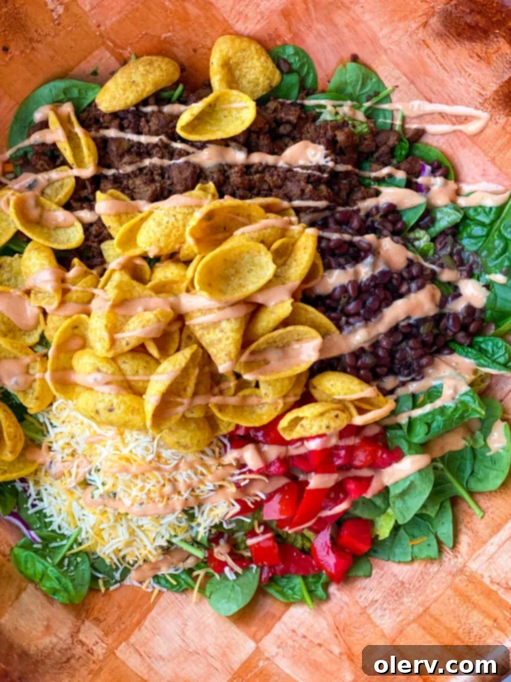 Frito Fiesta Salad 2 A large, vibrant Zesty Tossed Frito Salad in a white bowl, ready to serve, garnished with salsa.
