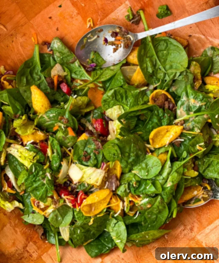 Frito Fiesta Salad 5 A generous portion of Zesty Tossed Frito Salad in a serving bowl, garnished with a spoon of salsa.