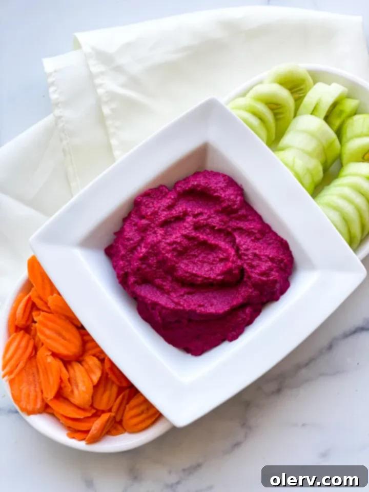 Vibrant Beet Hummus 6 Beet hummus served in a bowl with fresh herbs and a spoon