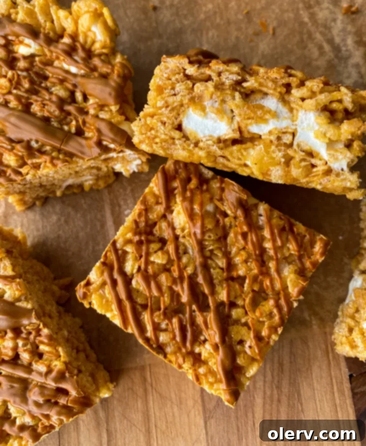 Autumn Pumpkin Crispy Delights 4 Hand holding a square pumpkin rice krispie treat with cinnamon drizzle
