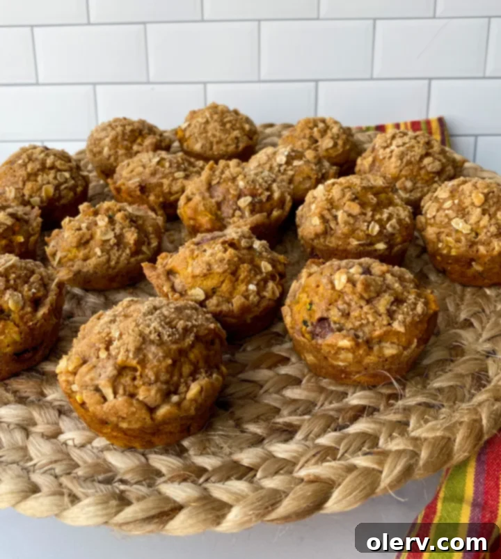 Cozy Autumn Muffins 6 A tray of freshly baked pumpkin zucchini muffins with golden-brown streusel topping cooling on a wire rack.