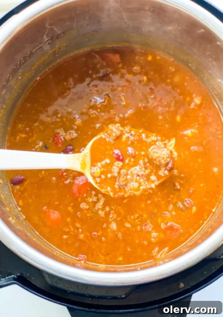 Hearty Pumpkin Chili Recipe 7 A top-down view of a bowl of pumpkin chili with a spoon, highlighting its creamy texture.