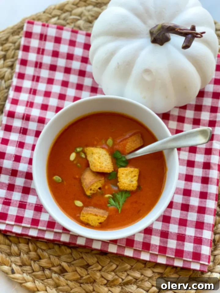 Velvet Roasted Red Pepper Pumpkin Soup 8 A large pot of freshly prepared, creamy roasted red pepper and pumpkin soup, garnished with fresh parsley, ready to be served hot.