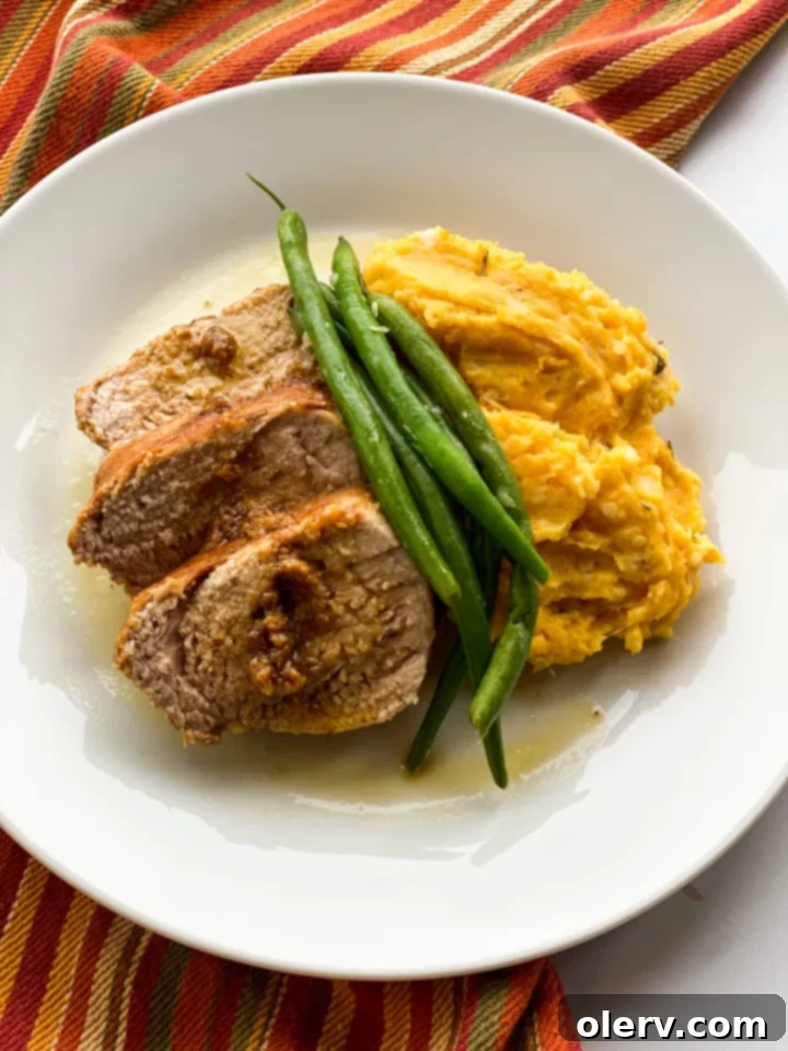 Harvest Gold Cheddar Mash 2 A close-up shot of a bowl of creamy Cheddar Pumpkin Mashed Potatoes, garnished with fresh rosemary.