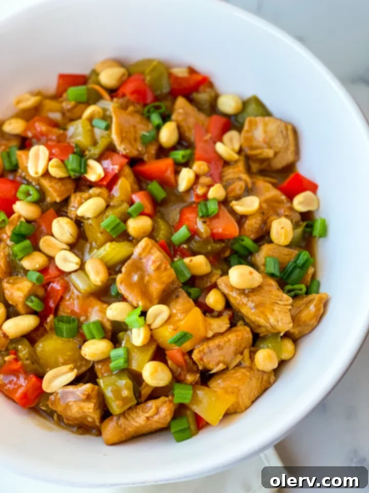 Speedy Instant Pot Kung Pao Chicken 2 Close-up of freshly cooked Instant Pot Kung Pao Chicken, garnished with vibrant green onions and crunchy peanuts, ready to be served over rice.