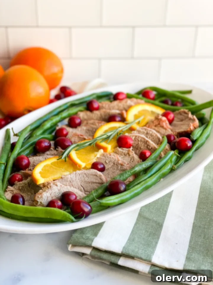 Instant Pot Cranberry Orange Glazed Pork Tenderloin 6 Slices of Instant Pot Cranberry Orange Pork Tenderloin arranged beautifully on a serving dish.