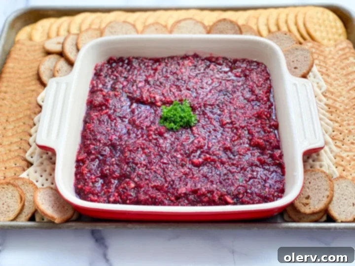 Creamy Cranberry Delight 7 Cranberry Cream Cheese Dip served on a plate with an assortment of crackers