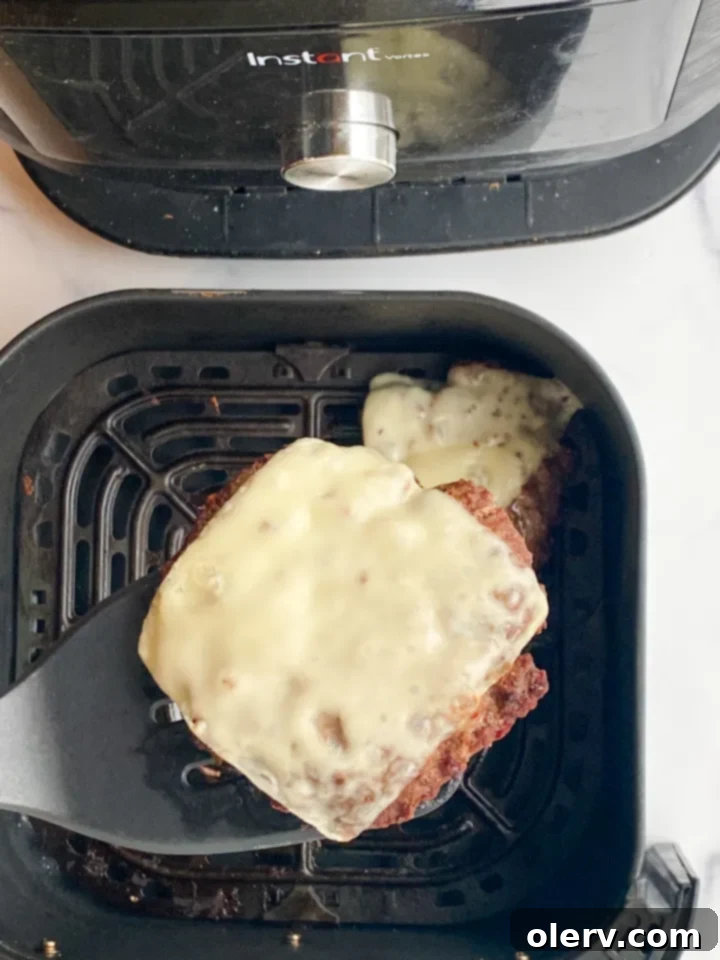 Perfect Air Fryer Burgers 5 Four perfectly formed, seasoned hamburger patties laid out on a cutting board, ready for cooking.