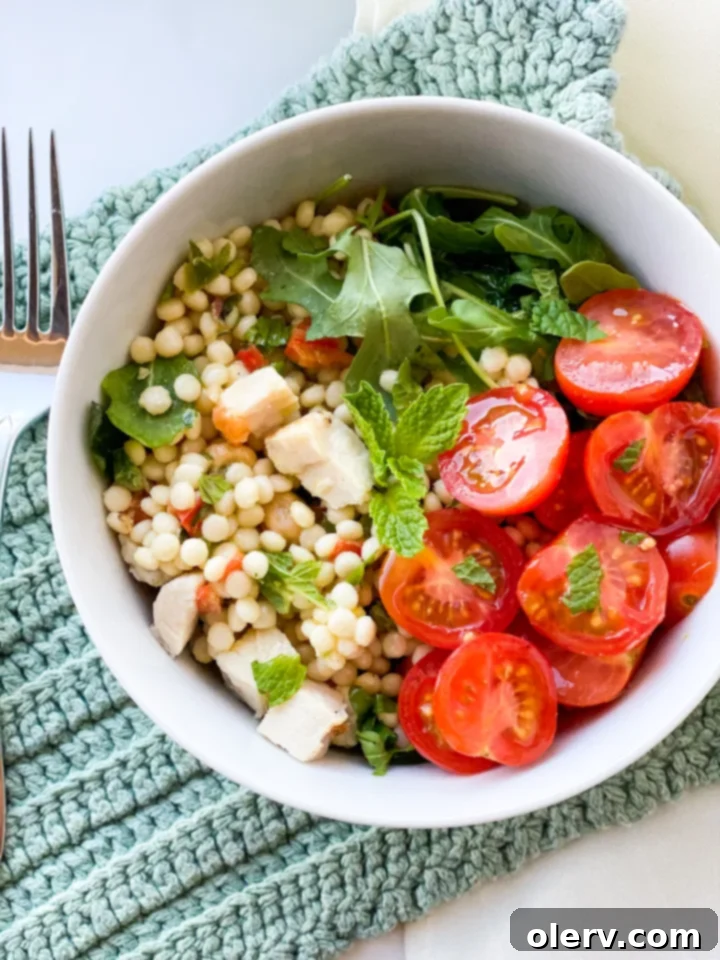 Vibrant Lemon Arugula Couscous Medley 2 A vibrant bowl of lemon arugula couscous salad with fresh mint and cherry tomatoes, ready to be served.