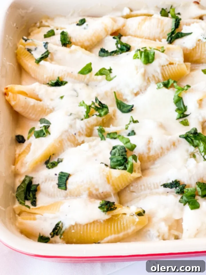 Creamy Ricotta Stuffed Shells 6 Another close-up of the finished baked pasta, showing a serving spoon lifting a shell.