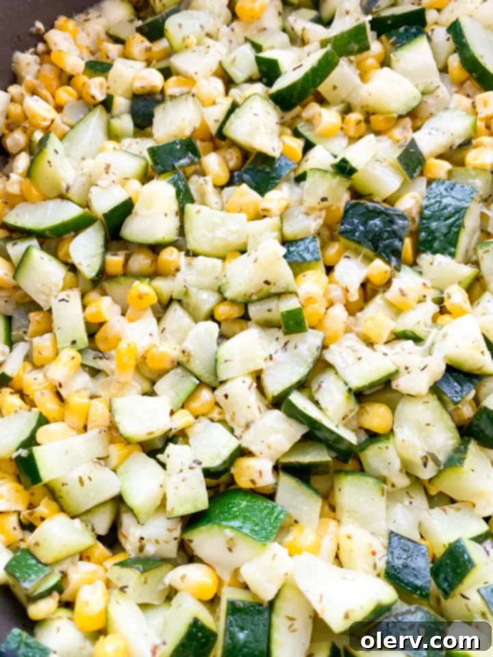 Savory Zucchini Side 5 Ingredients for zucchini and corn side dish laid out: olive oil, garlic, diced zucchini, corn, lime, Italian seasoning, salt, pepper, and Parmesan