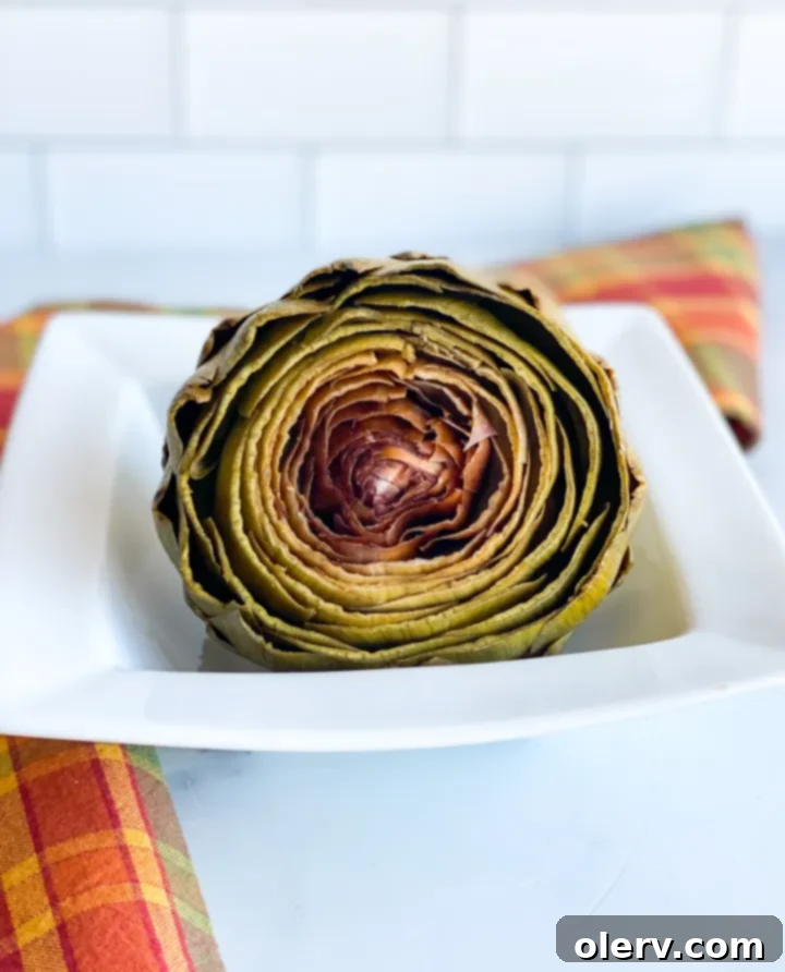 Easy Instant Pot Artichokes 2 Fresh artichokes ready for Instant Pot preparation on a cutting board
