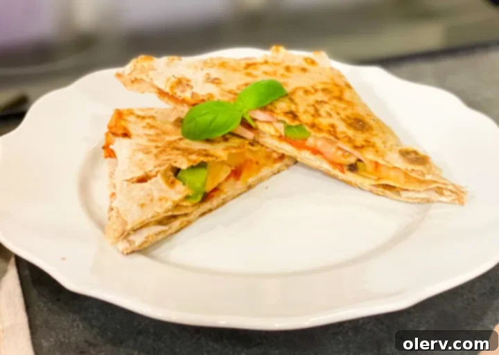 Craft Your Own Pizza Pockets 3 Close-up of a half-folded lavash wrap with pizza sauce, mozzarella, and pepperoni, showing the preparation stage of a homemade pizza pocket.