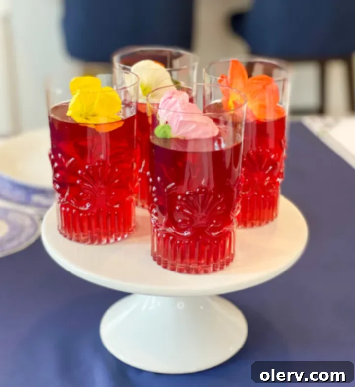 Mother's Day Celebration 5 Glasses of vibrant red hibiscus tea adorned with fresh edible flowers