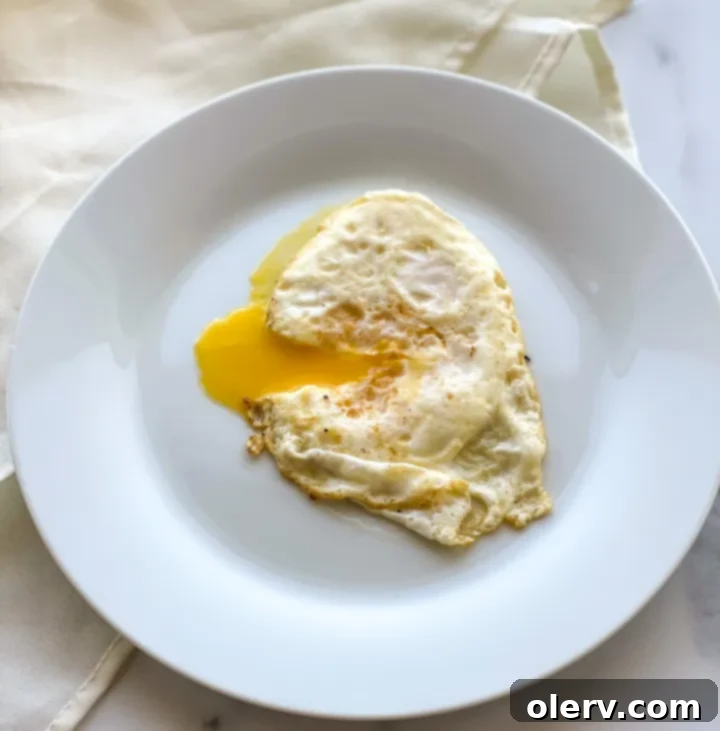 Mastering the Egg 6 Over easy egg with a glistening, runny yolk served on a clean white plate