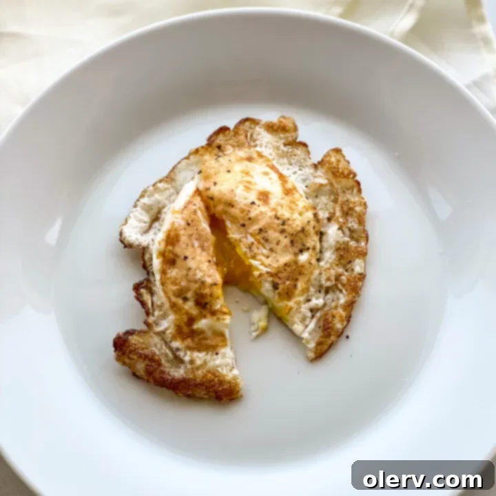Mastering the Egg 7 Over medium egg with a slightly set, velvety yolk on a white plate, showcasing its texture