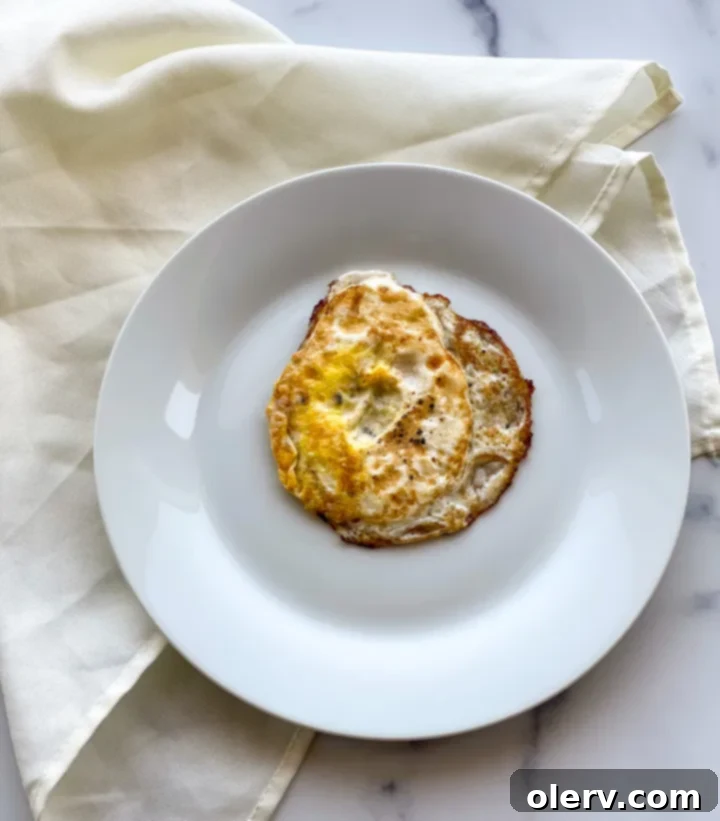 Mastering the Egg 8 Two perfectly cooked over hard eggs on a plate, showing completely set yolks
