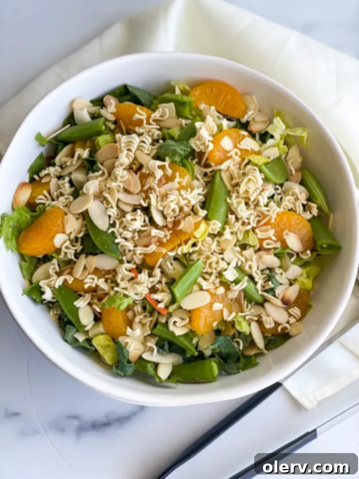 Mandarin Sesame Chicken Salad 6 A large bowl of fully mixed Chinese Chicken Salad with dressing, ready to be served.