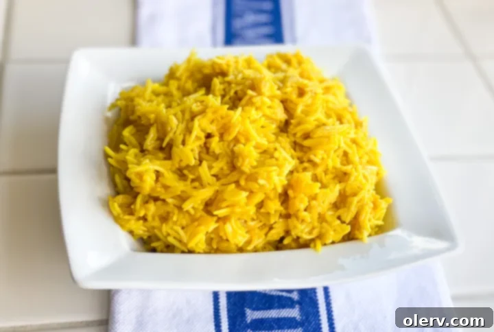 Zesty Greek Lemon Rice 3 A close-up view of freshly cooked, bright yellow Instant Pot Greek Lemon Rice, showcasing its fluffy texture and the vibrant hue imparted by turmeric and fresh lemon.