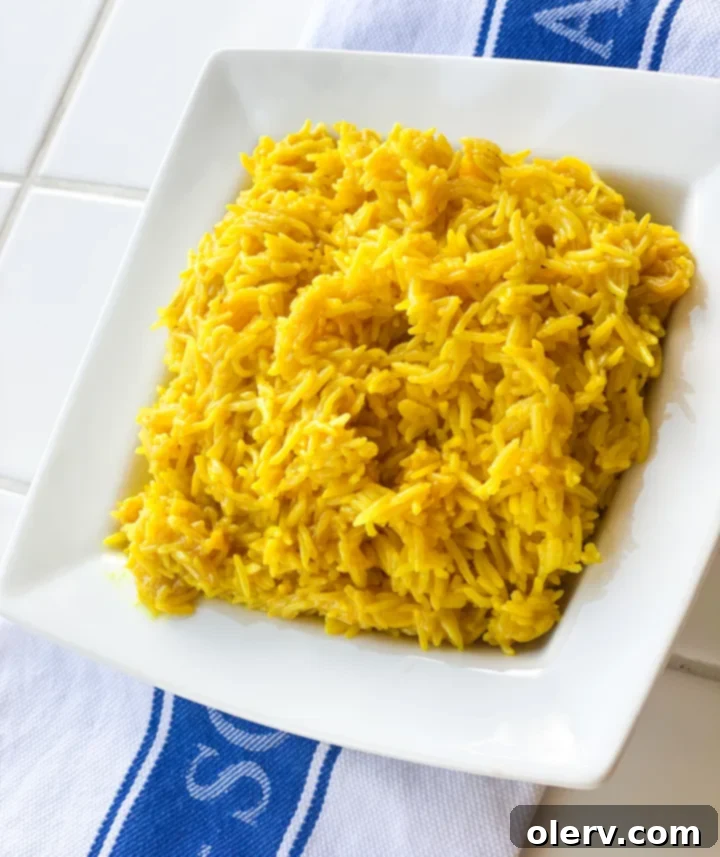 Zesty Greek Lemon Rice 4 A serving spoon lifting a generous portion of fluffy, golden Greek Lemon Rice from a bowl, highlighting its texture and inviting appearance.