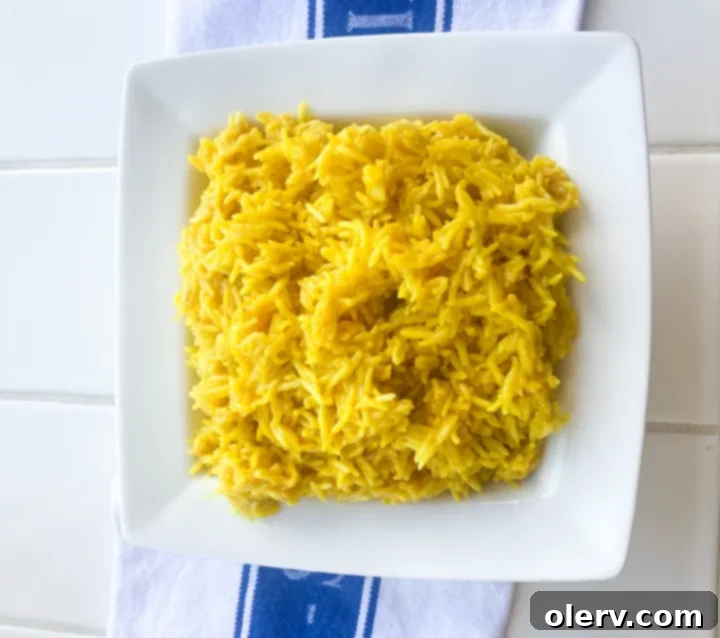 Zesty Greek Lemon Rice 5 A beautifully presented bowl of Instant Pot Greek Lemon Rice, garnished with fresh herbs and lemon wedges, ready for serving.