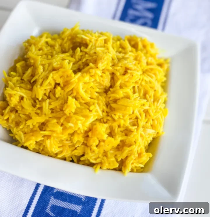 A large bowl of Instant Pot Greek Lemon Rice ready to be served, with a spoon for scooping, garnished with herbs and lemon slices.