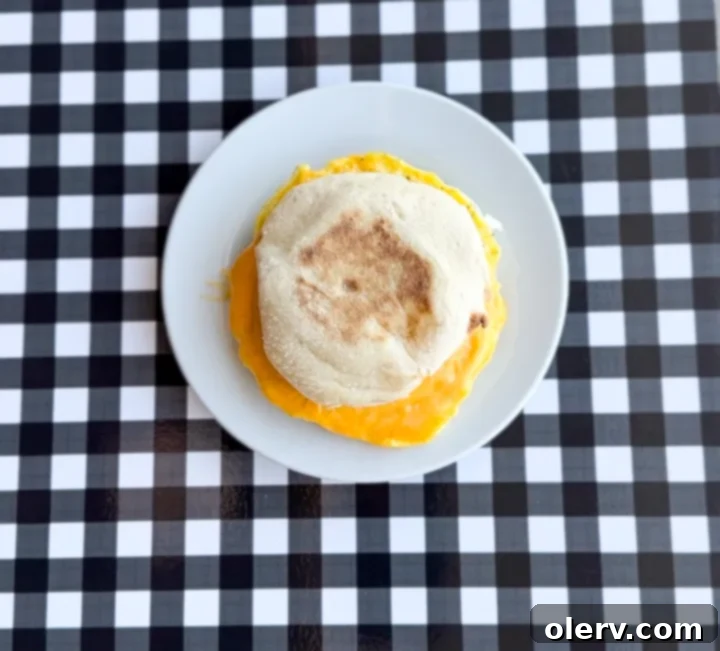 Instant Breakfast Sandwich 12 Step 8: Placing the cooked egg, ham, and melted cheese onto the toasted English muffin