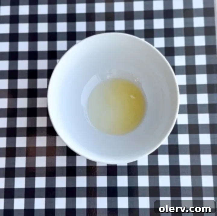 Instant Breakfast Sandwich 5 Step 1: Whisking an egg with a fork in a glass bowl