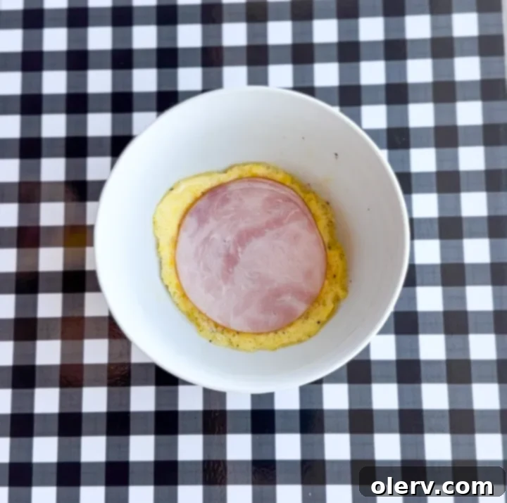 Instant Breakfast Sandwich 8 Step 4: Placing a slice of ham on the cooked egg patty