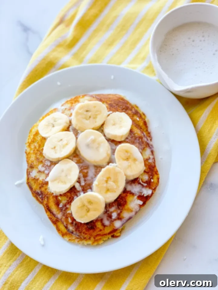 Liquid Coconut Gold 3 Collection of key ingredients for coconut syrup laid out on a white surface: canned coconut milk, cornstarch, white sugar, salt, corn syrup, and coconut extract.