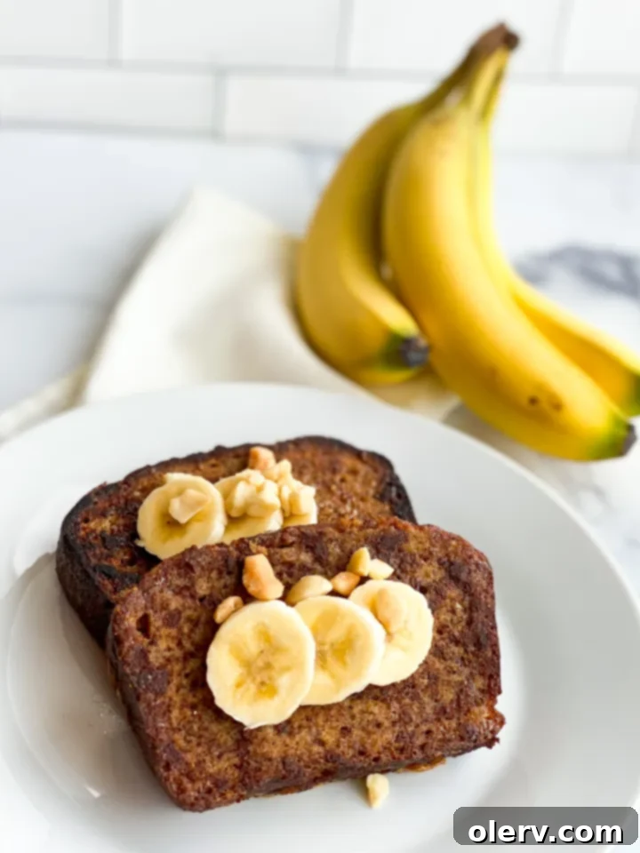 Heavenly Banana Bread French Toast 6 A beautifully plated stack of Banana Bread French Toast with fresh bananas, coconut syrup, and macadamia nuts