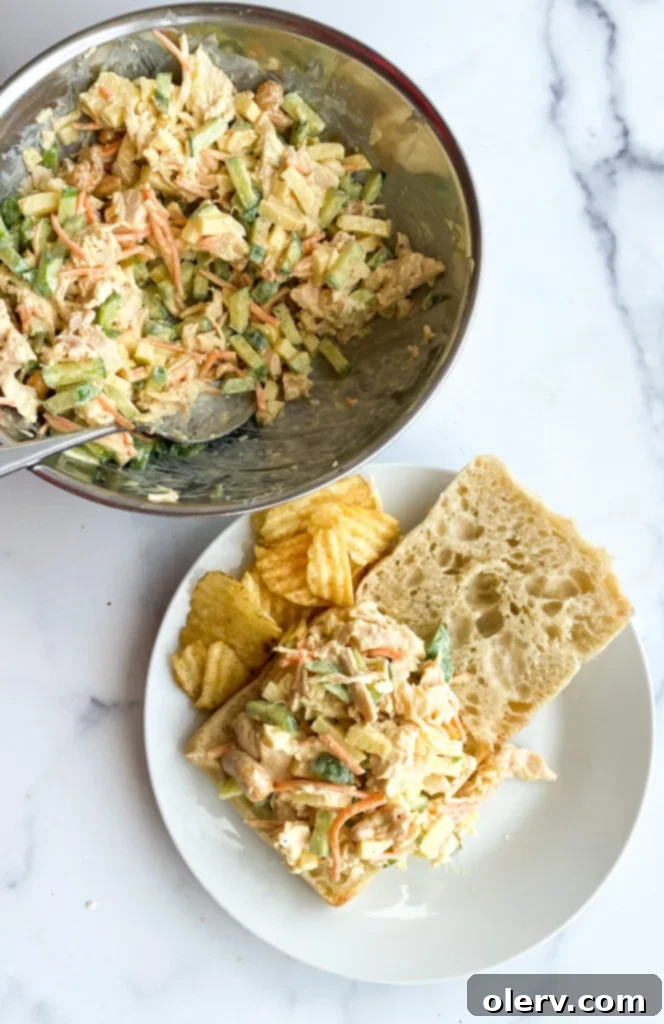 Aromatic Curry Chicken Salad 6 Hand scooping curry chicken salad into a serving bowl