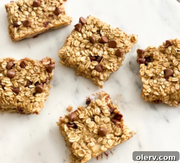 Golden Banana Baked Oats 5 Ingredients for banana baked oatmeal laid out, including oats, mashed bananas, chocolate chips, and syrup