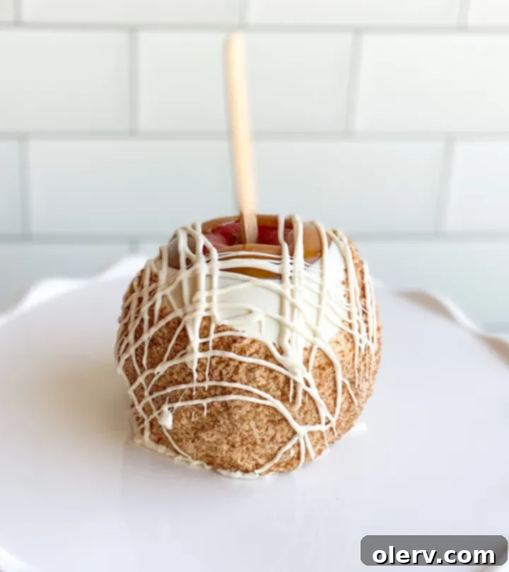 Easy Homemade Caramel Apples 3 A person dipping an apple into a bowl of rich caramel