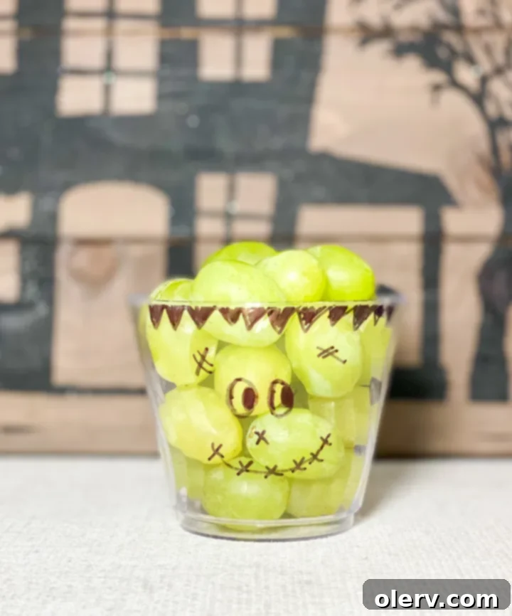 Monster Munchie Cups 6 Franken-Fruit Cup with green grapes and a drawn Frankenstein face on the cup