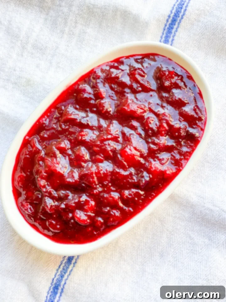 Instant Pot Cranberry Sauce in a beautiful serving bowl with fresh cranberries