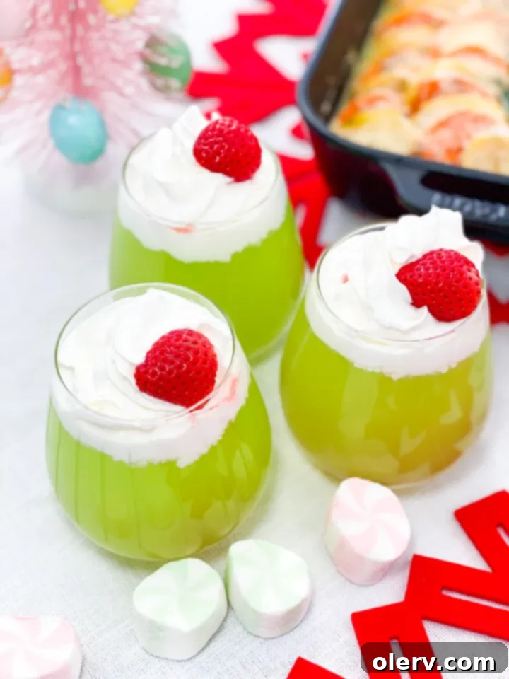 The Grinch's Feast 11 Grinch Juice, a green beverage topped with whipped cream and a strawberry heart