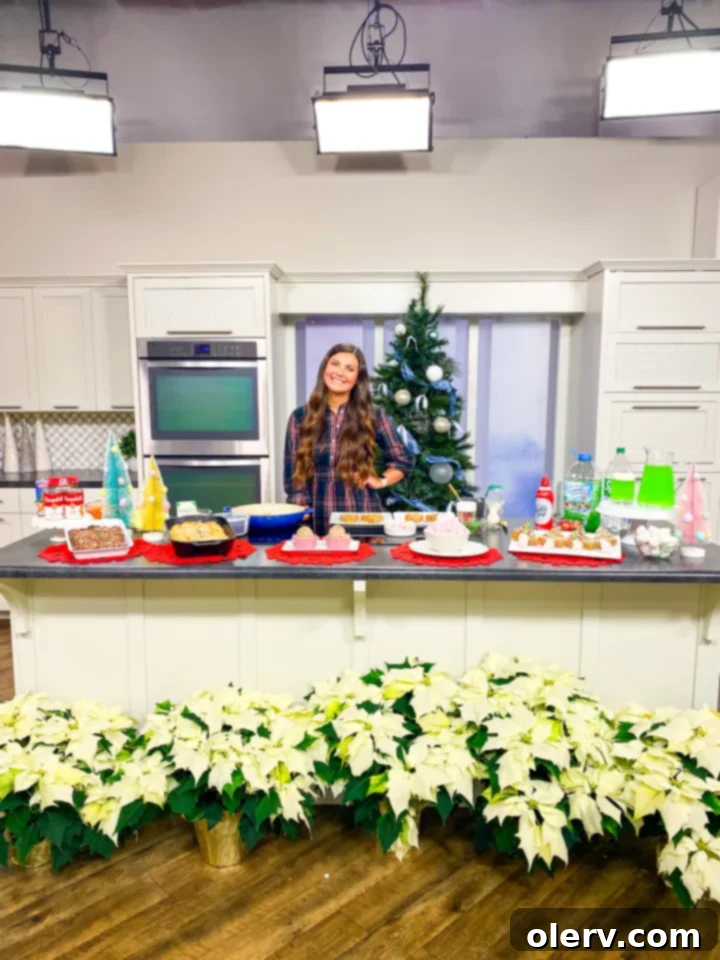 The Grinch's Feast 13 Alex Daynes holding a glass of Grinch Juice on a TV show set