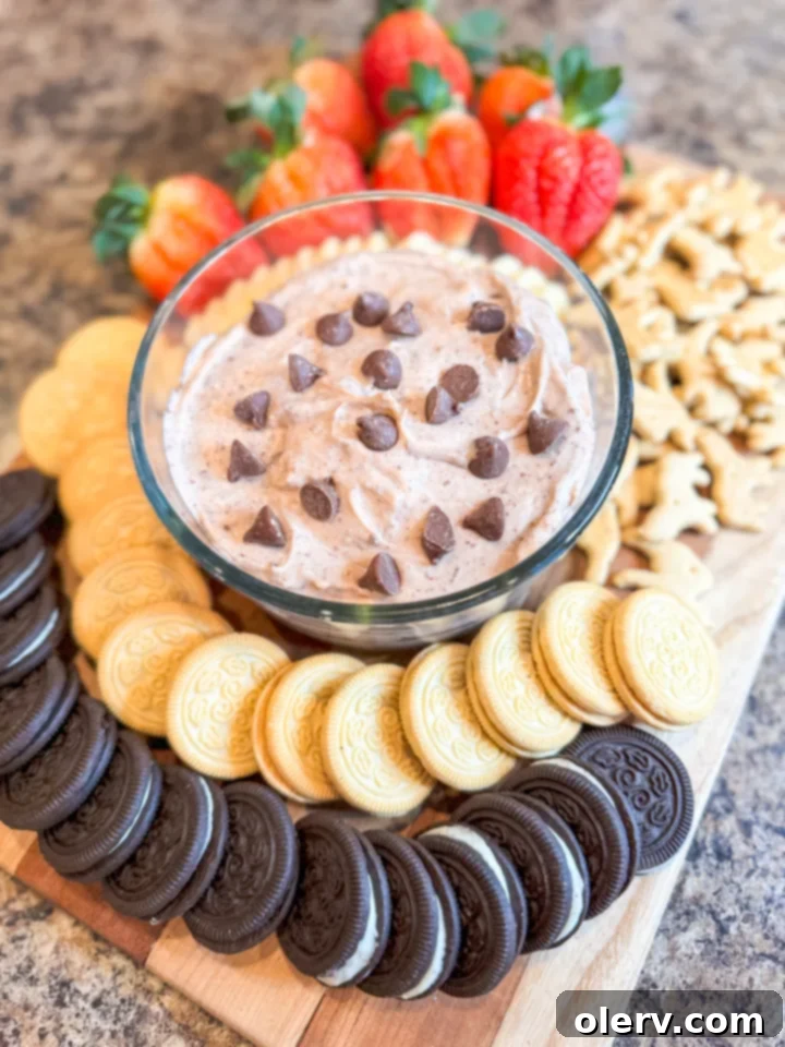 Irresistible Chocolate Chip Dip 4 A spoon scooping a generous portion of creamy chocolate chip dip from a white serving bowl, highlighting its smooth texture and visible chocolate chips.