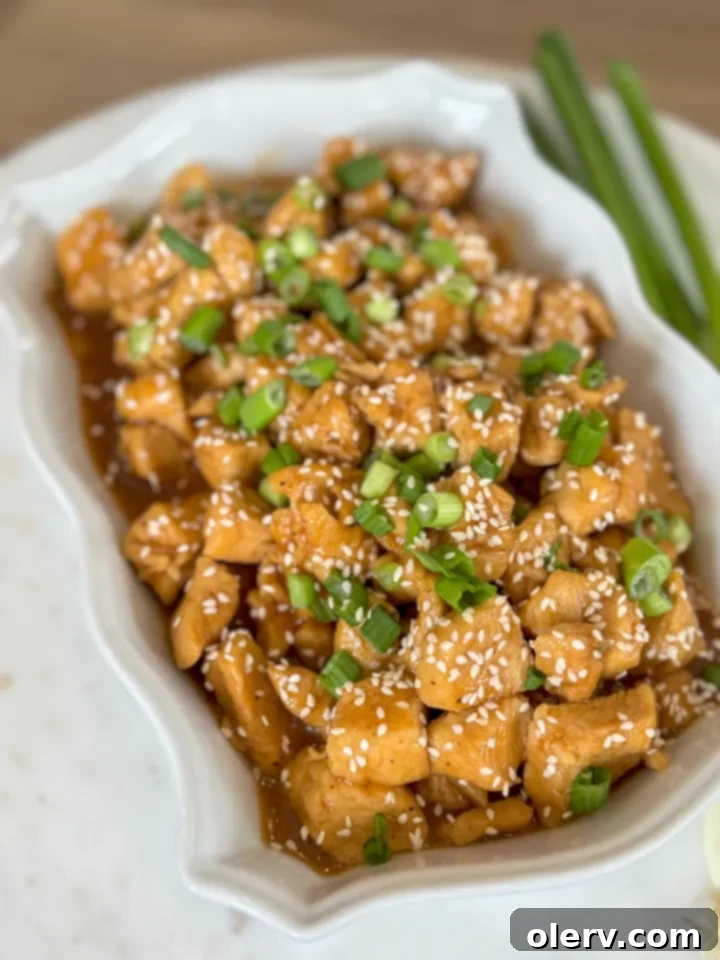 Sticky Honey Sesame Chicken 2 Delicious honey sesame chicken served with rice and garnished with green onions and sesame seeds.