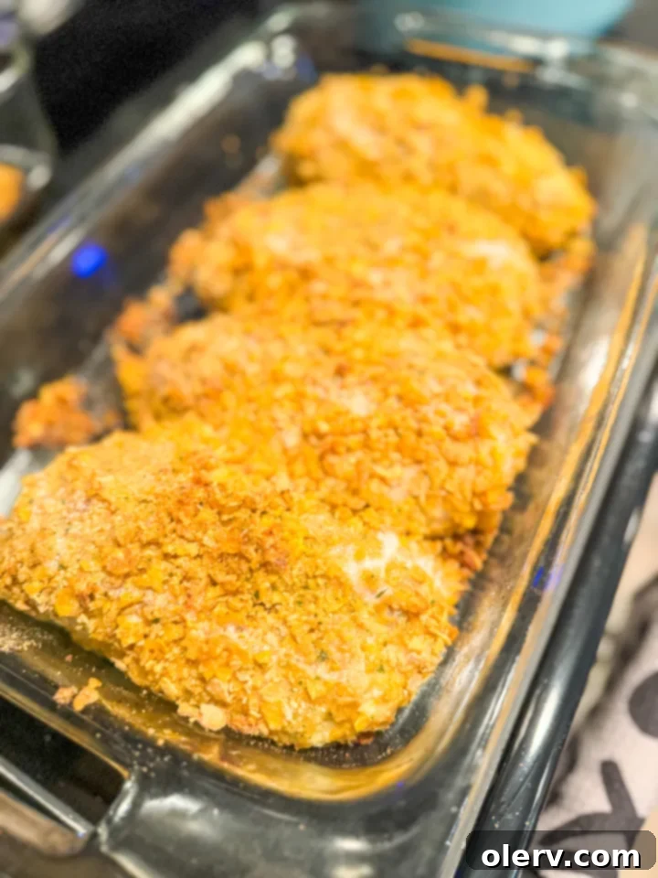 Golden Crispy Ranch Chicken 5 Bowls of ingredients: whisked eggs, crushed cornflakes with ranch seasoning, and raw chicken breasts