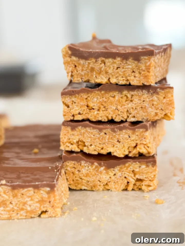 Irresistible No-Bake Scotcheroo Bars 3 Close-up of a stack of Scotcheroo bars, showing the crispy cereal base and glossy chocolate-butterscotch topping.