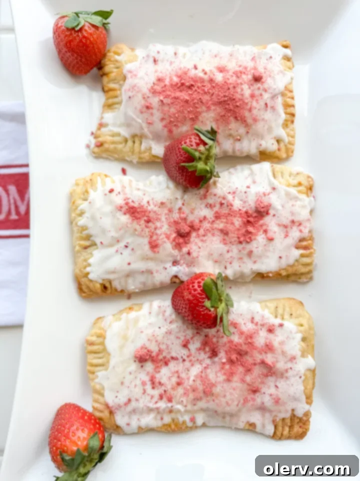 Frosted Strawberry Bliss 3 A close-up of a perfectly baked homemade strawberry Poptart, showing its golden crust and delicious filling peeking through.